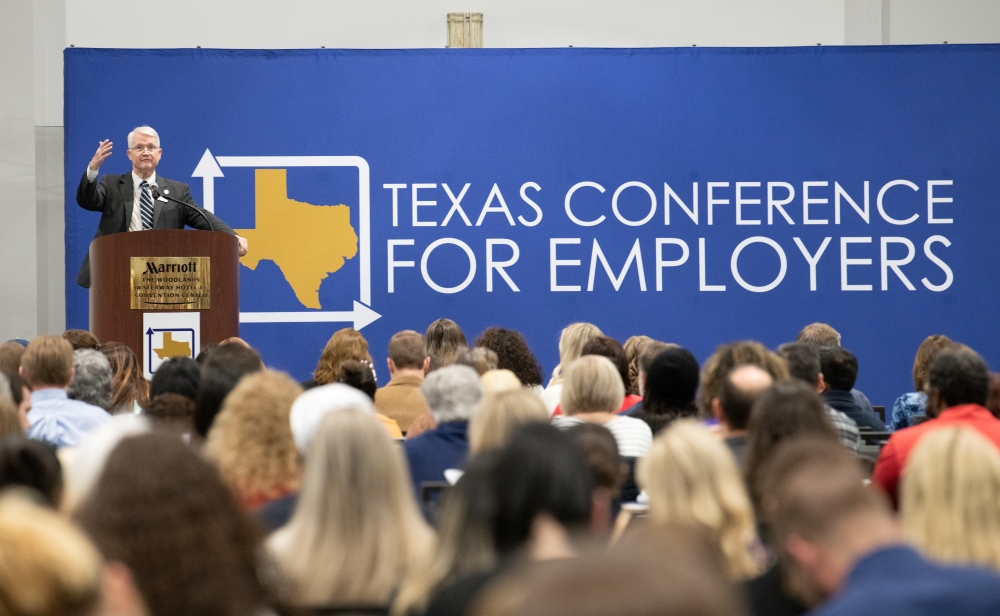 Photo of a speaker at the podium facing the crowd at the Texas Conference for Employers conference. 